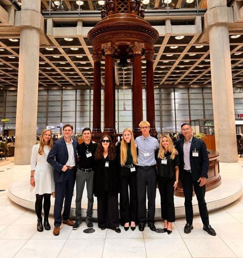 A group of people in formal attire standing at Lloyd's, London