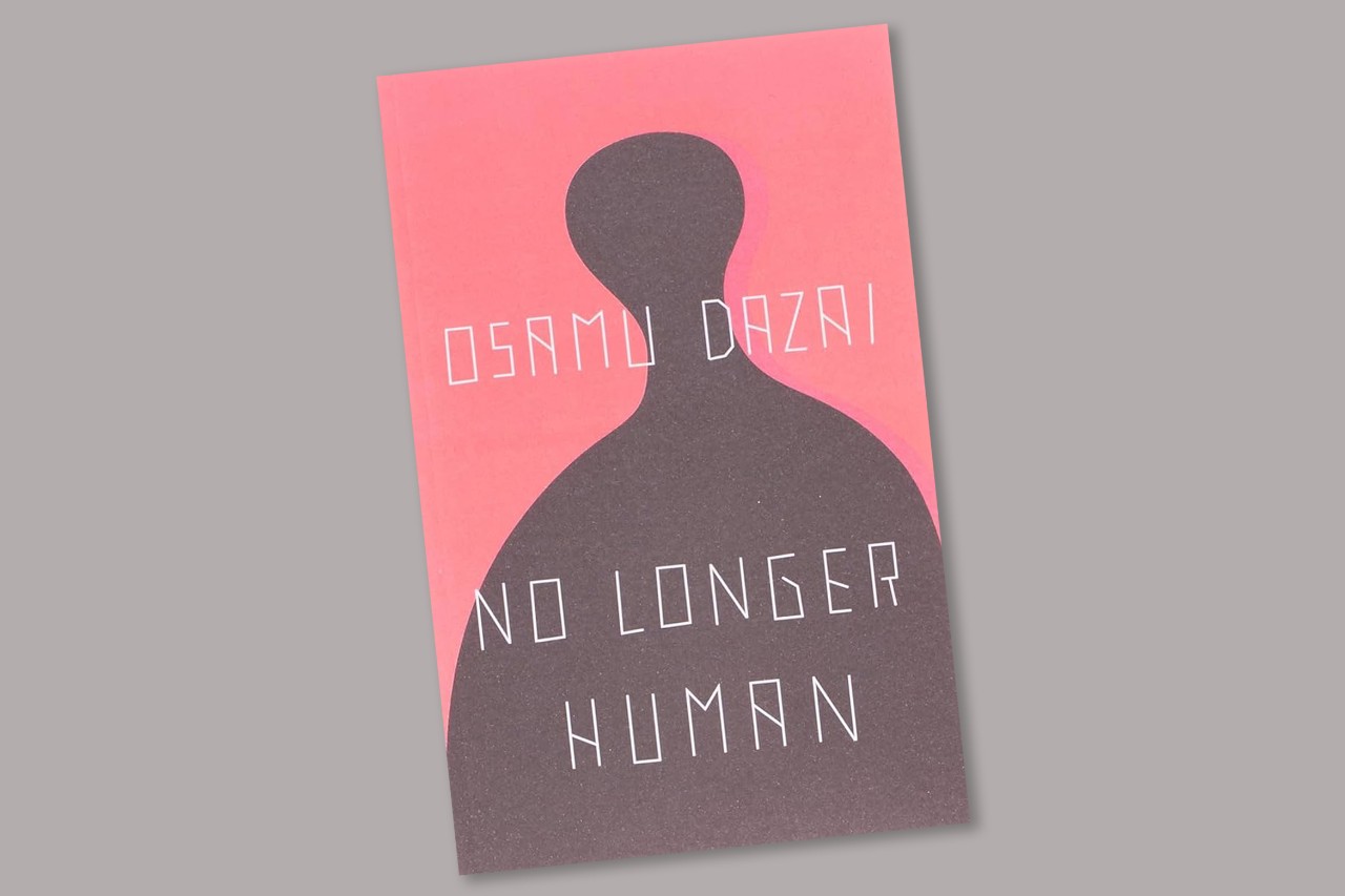 The cover of the book No Longer Human by Osamu Dazai sits in front of a grey background