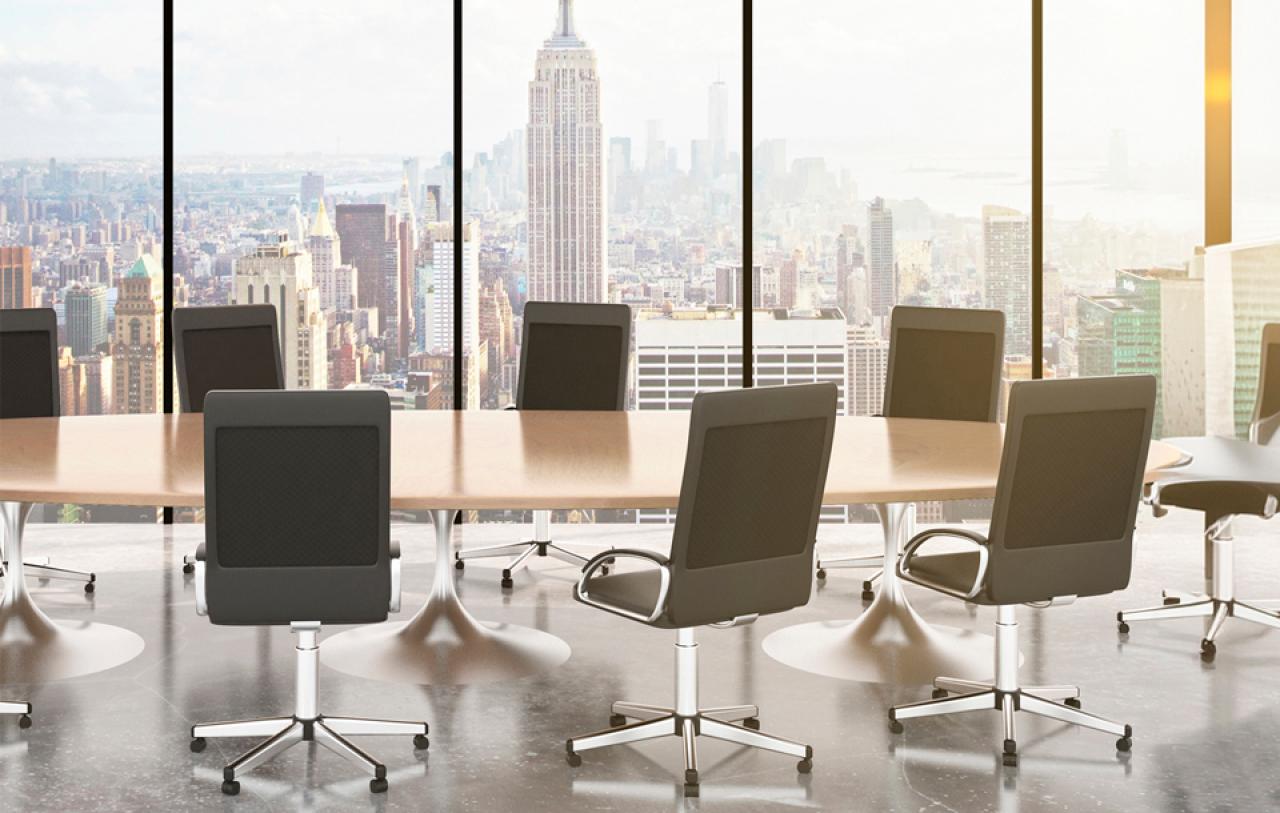 Chairs are placed at a table overlooking the NYC skyline