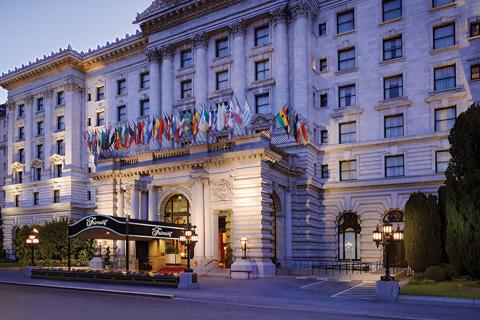 The Fairmont hotel with classic architecture and a row of international flags above its entrance.