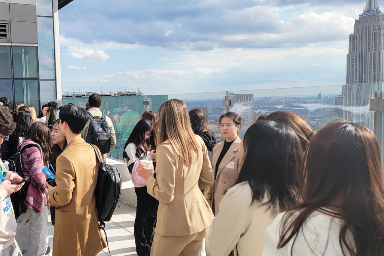 NYU SPS students mill about a skydeck on a sunny day while visiting TikTok for a day.
