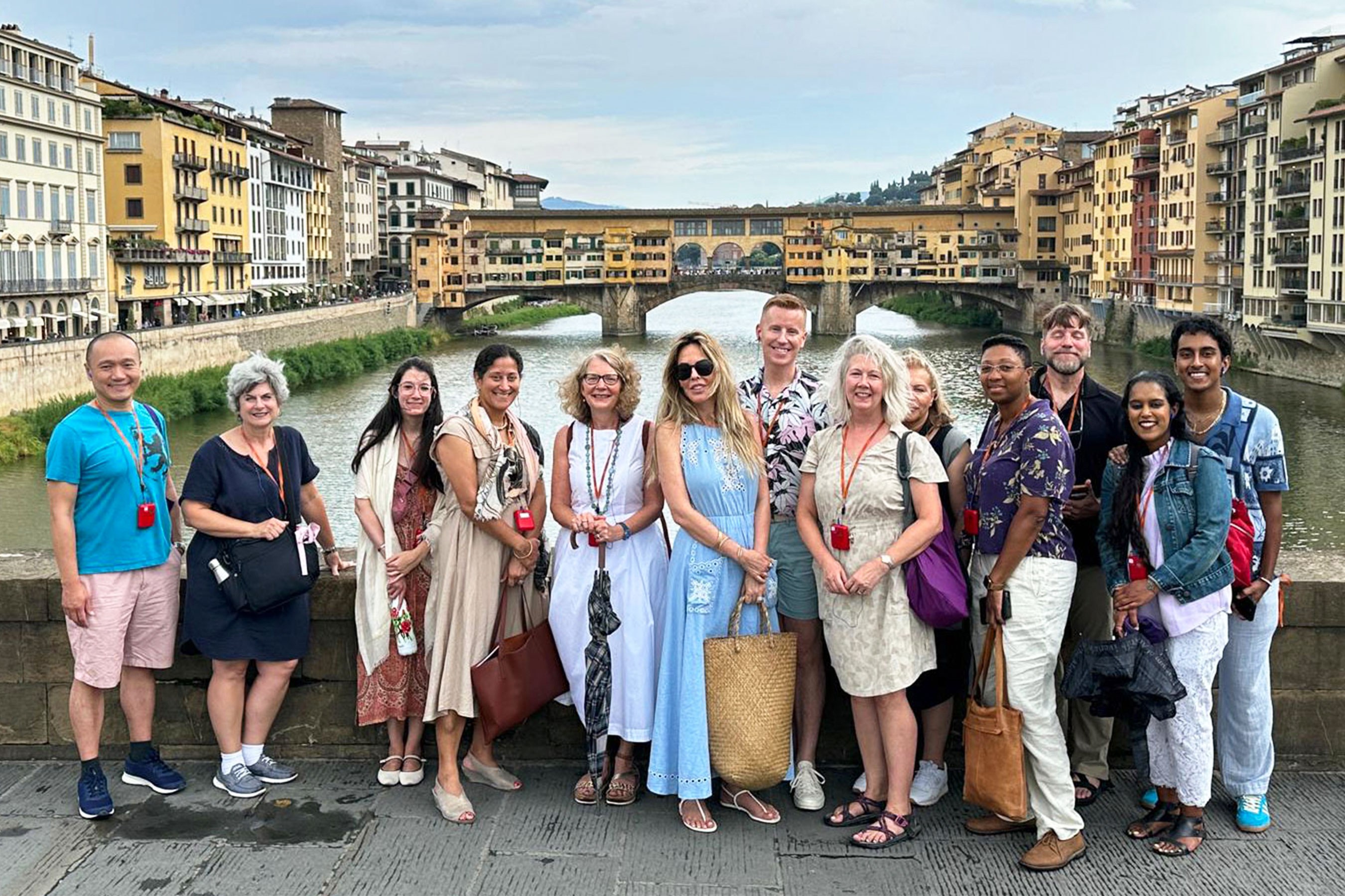 A group of NYU SPS alumni smile for a photo on a bridge during the Inaugural Alumni Travel Program in Florence