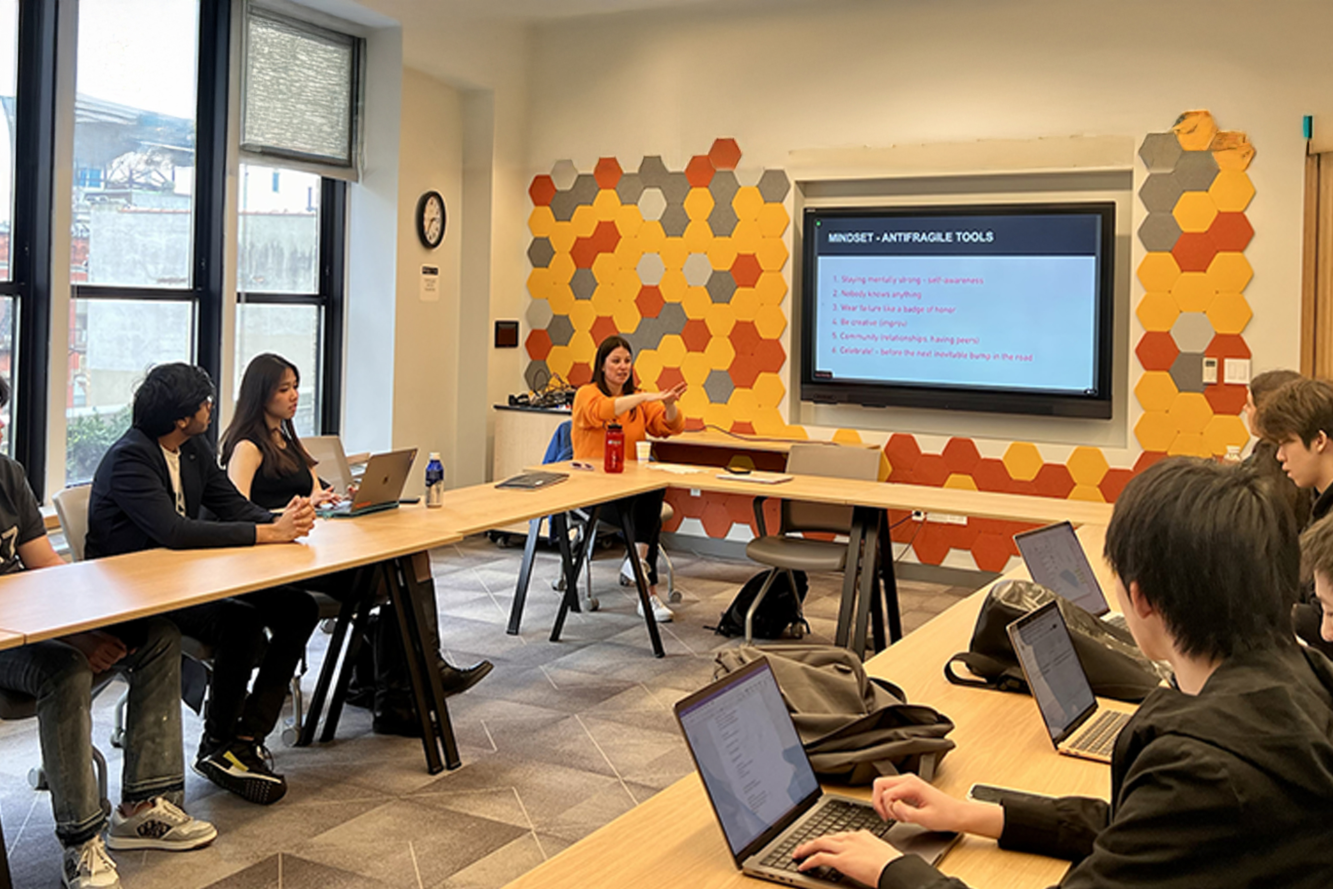 A classroom with students sitting together looking at a screen.