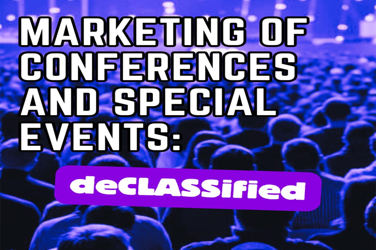 An audience sits attentively in an auditorium.