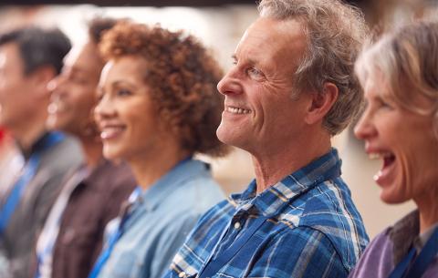 A row of continuing education students smile while looking in the same direction