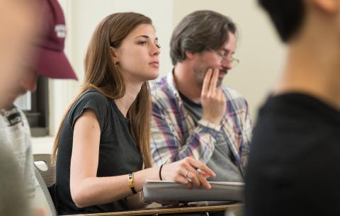 A female Division of Applied Undergraduate Studies student holds a notebook and a pen during class at NYU SPS