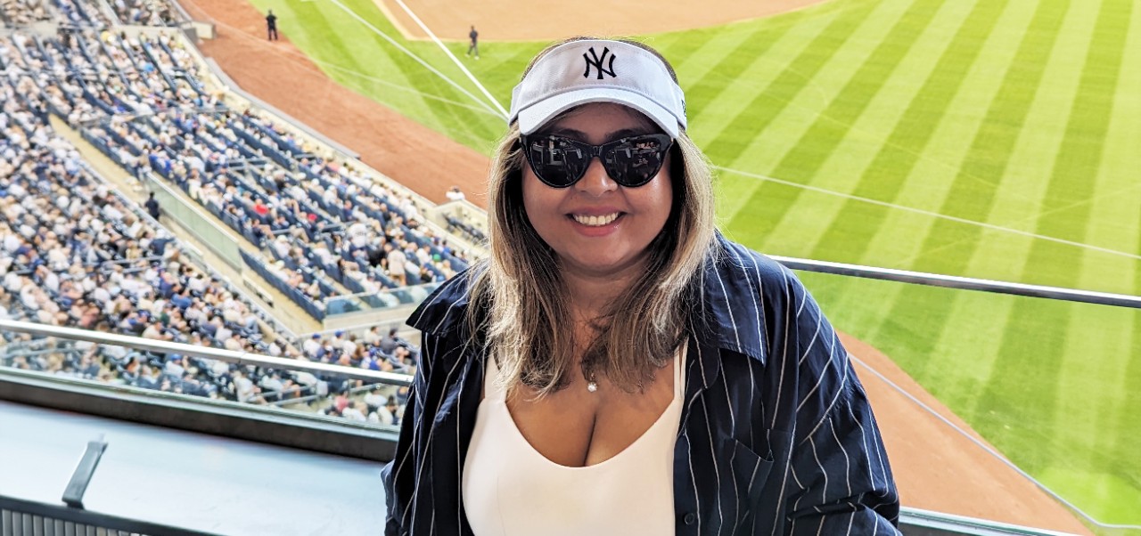 Bhavana Singh, Division of Programs in Business at NYU SPS alumnus, poses for a selfie at a professional baseball game.