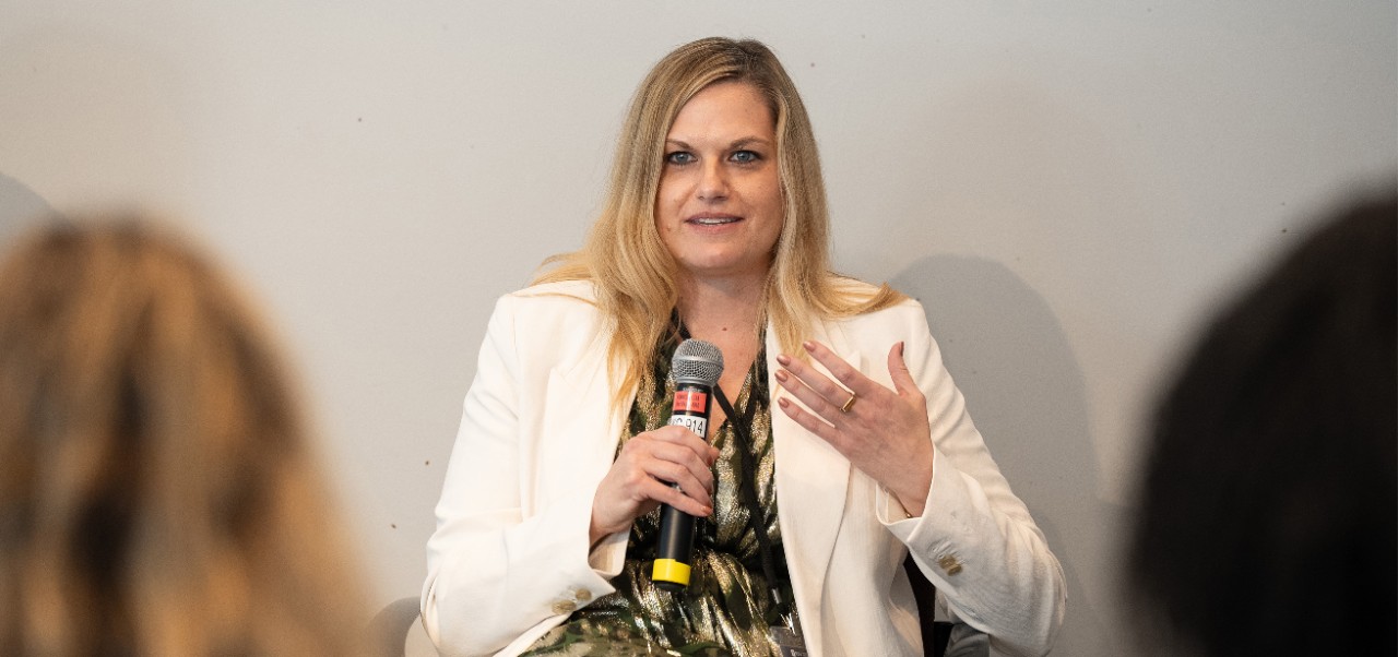 Cathy Merritt, Division of Programs at NYU SPS alumnus, addresses a crowd while holding a microphone.