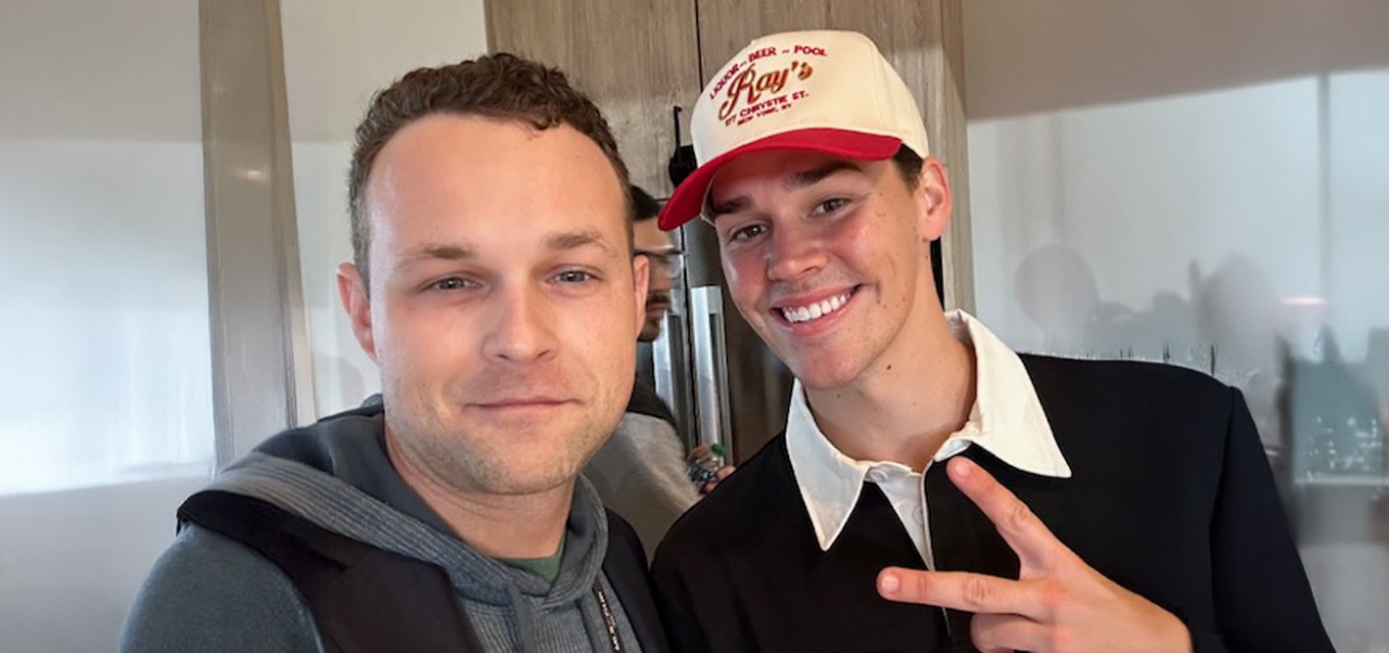 NYU SPS alumnus John Rose takes a selfie with a friend who holds up peace fingers