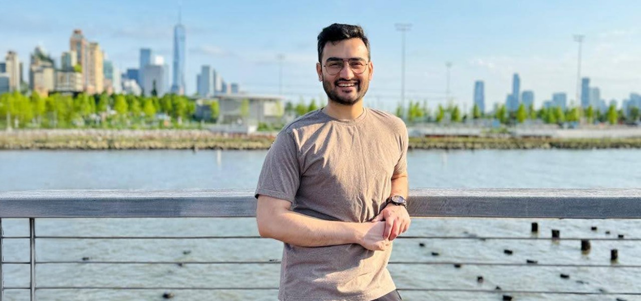 Division of Programs in Business at NYU SPS alumnus Prithviraj Rathore smiles for the camera with the Manhattan skyline in the background on a sunny day.