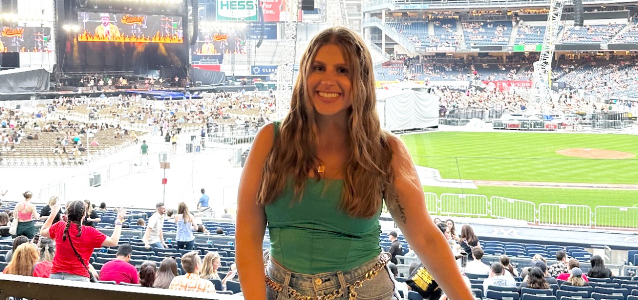 Rebecca Bodtmann, Preston Robert Tisch Institute for Global Sport alumni at NYU SPS, poses for a photo at a professional baseball game.