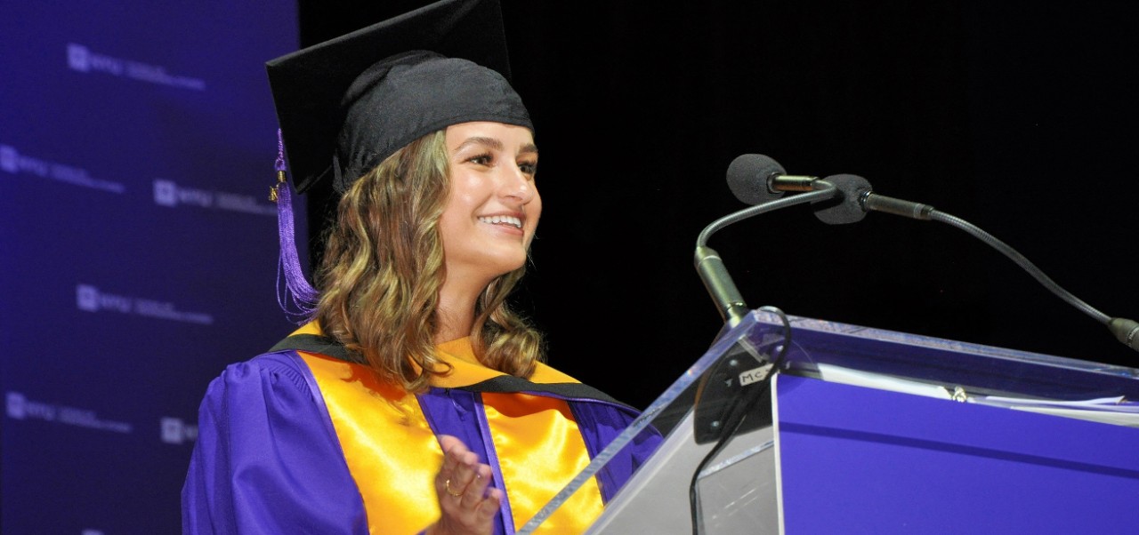 Roksolana Maria Sheverack, NYU SPS Division of Programs in Business alumnus, pauses to smile while giving a speech at graduation.