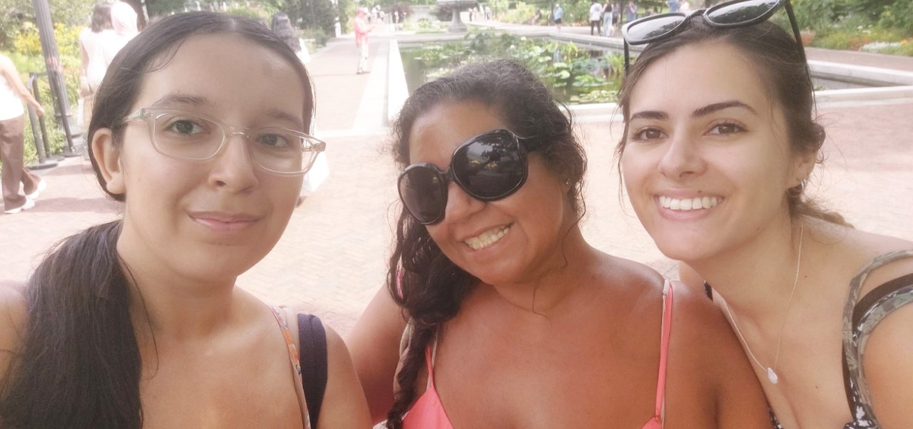 Samantha O'Connell, Center for Publishing and Applied Liberal Arts at NYU SPS alumnus, smiles for the camera with two girlfriends at a botanical garden.