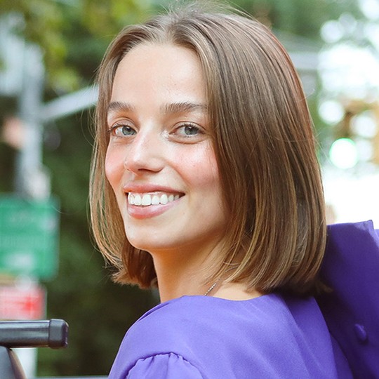 Jonathan Tisch Center of Hospitality alumnus Yasmine Barbes smiles for the camera while wearing graduation regalia.
