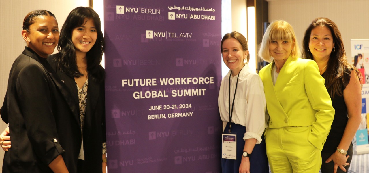 At the Future Workforce Global Summit in Berlin, Anna Tavis poses in front of a purple banner with four other women