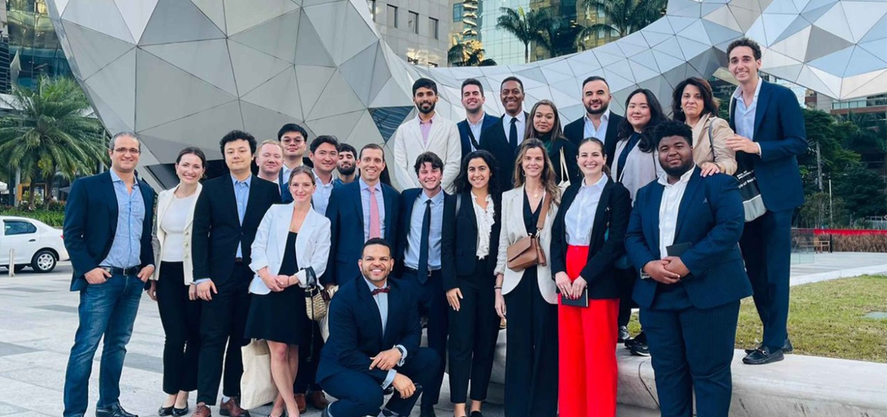 Marc Norman, Clinical Professor, Schack Institute of Real Estate, NYU SPS, poses for a photo with a large group of students during a trip to Brazil.
