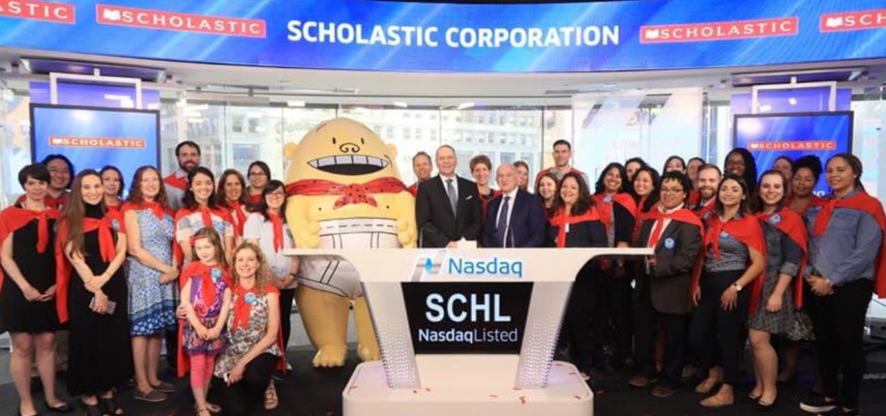 Mindy Stockfield, Adjunct Instructor, Center for Publishing, Writing, and Media at NYU SPS, poses for a photo with a group of colleagues while visiting NASDAQ.