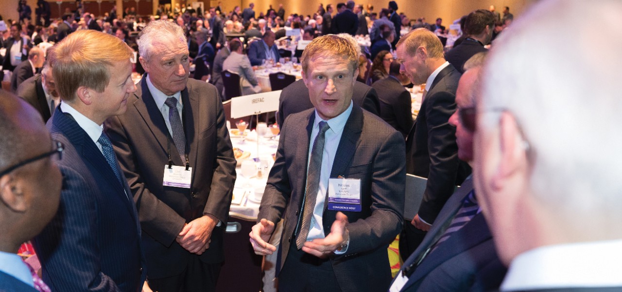 Nicolas Graf, Clinical Professor, Jonathan M. Tisch Center of Hospitality at NYU SPS networks with colleagues in a massive ballroom brimming with conference attendees.