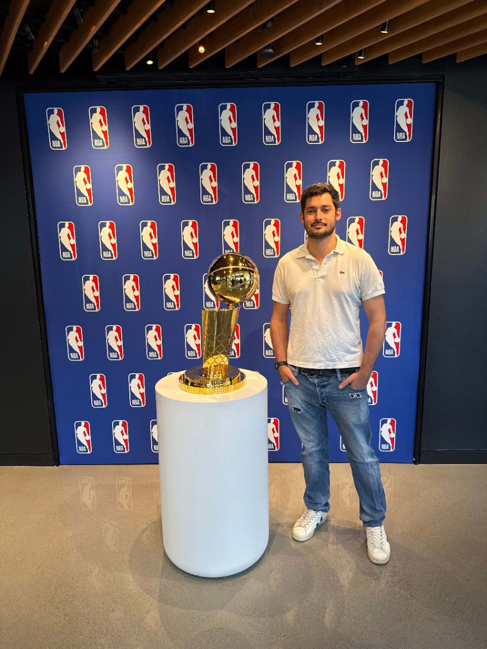 Gustavo Giusti stands beside a trophy.