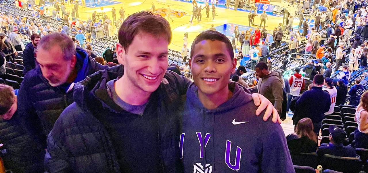 Maurice Moore, student at the NYU SPS Division of Applied Undergraduate Studies, poses for a photo with a friend at a professional basketball game. 