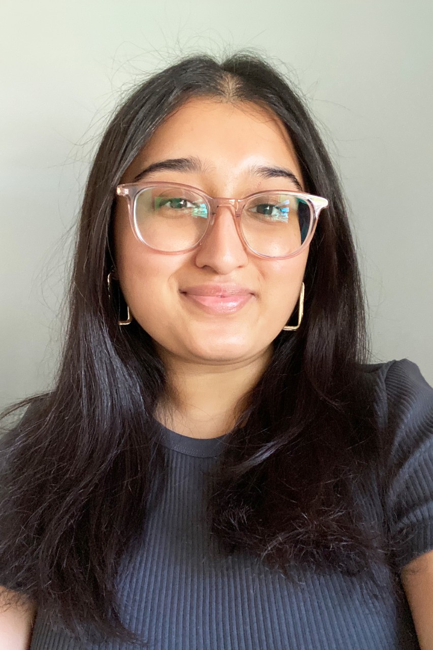 Meahjabeen Hoque smiles for a photo outside wearing a pink top