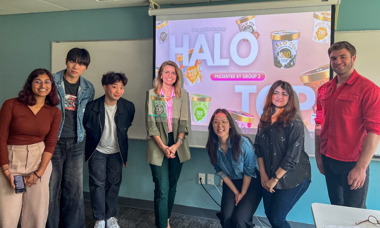 Michael Wang and fellow students pose in front of a screen.