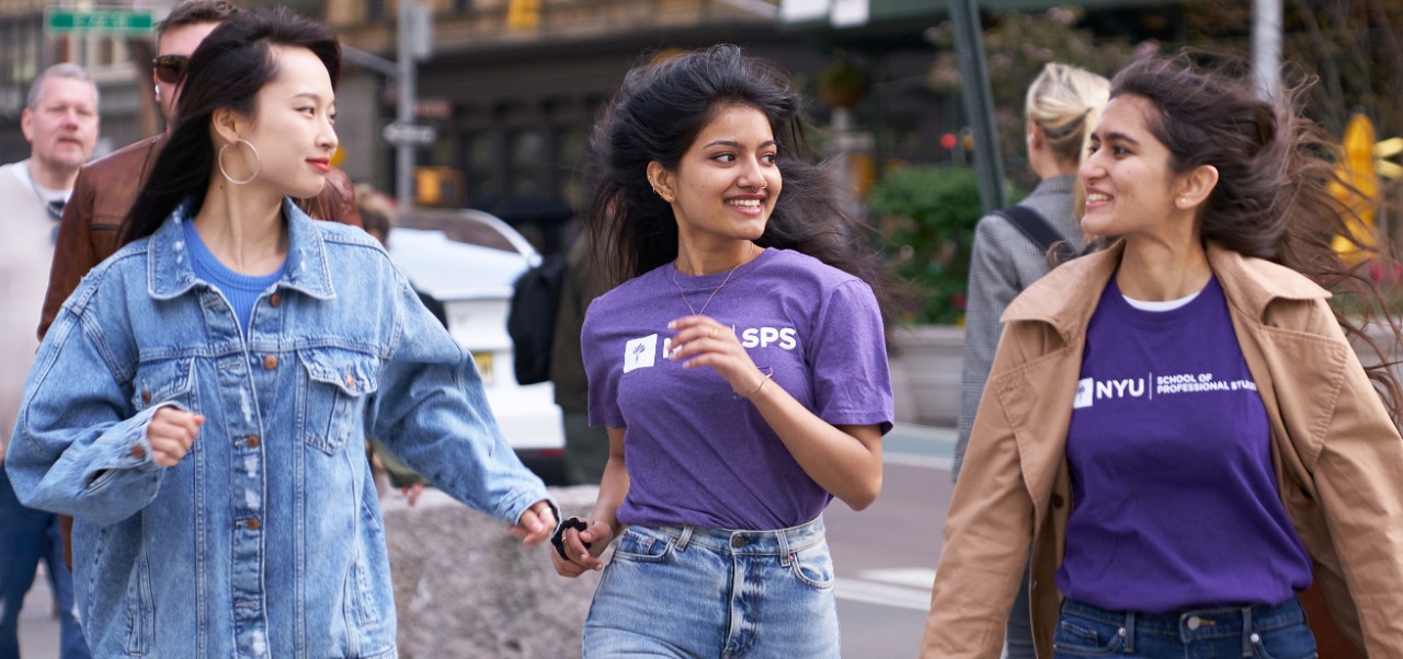 NYU SPS student Surabhi Achar walks down a busy Manhattan street with two friends on a windy day.