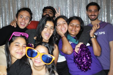 Students pose for a photobooth picture with props.