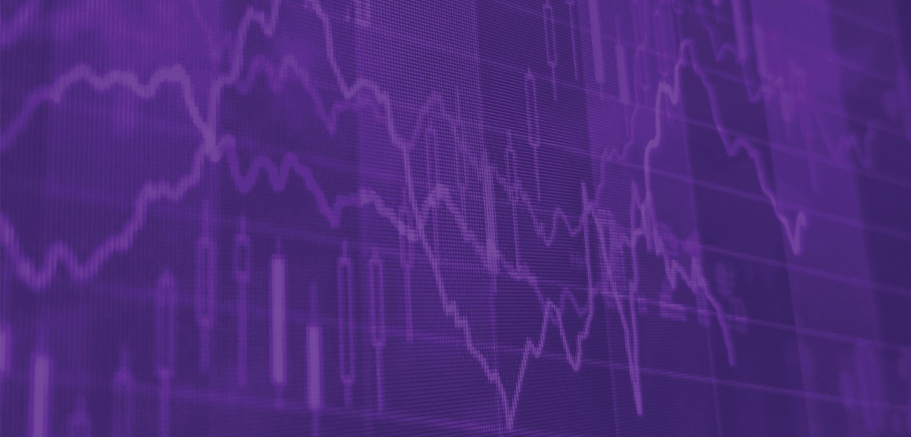 Man looks at his phone in front of Wall St.