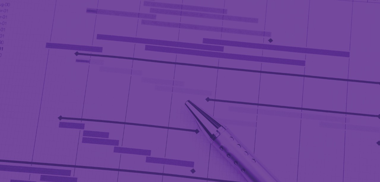 Three colleagues discuss a concept on a whiteboard while sunlight streams through a large window in the background.