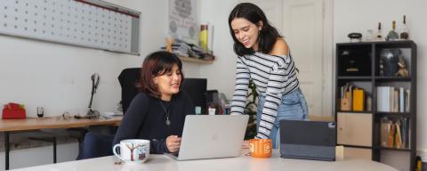 students looking something over on a laptop