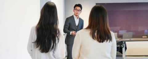students discussing with a professor in a classroom