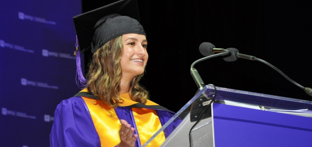 Roksolana Maria Sheverack, NYU SPS Division of Programs in Business alumnus, pauses to smile while giving a speech at graduation.