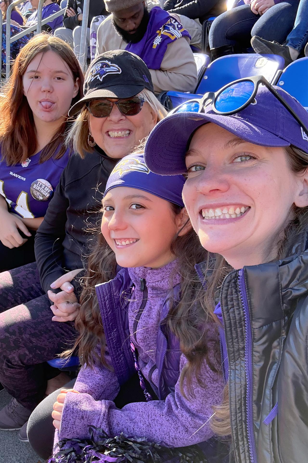 NYU SPS CE instructor Abby Crowley smiles for a photo with family members at a Baltimore Ravens football game