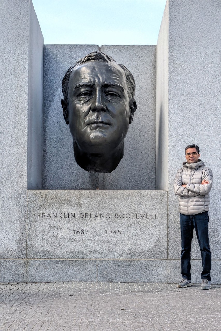 NYU SPS CE faculty member Amar Vajjhala stands cross-armed in front of the Franklin Delano Roosevelt monument