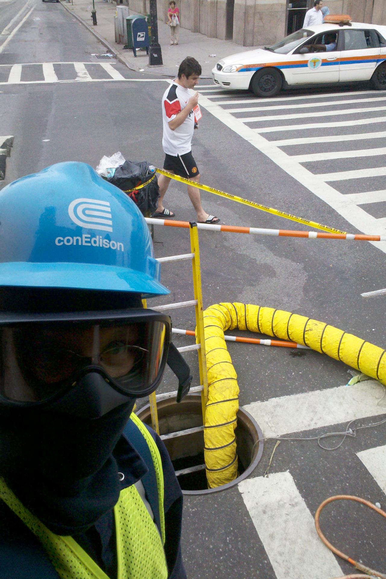 NYU SPS CE instructor Lucas Finco smiles for a photo wearing construction gear and a hardhat