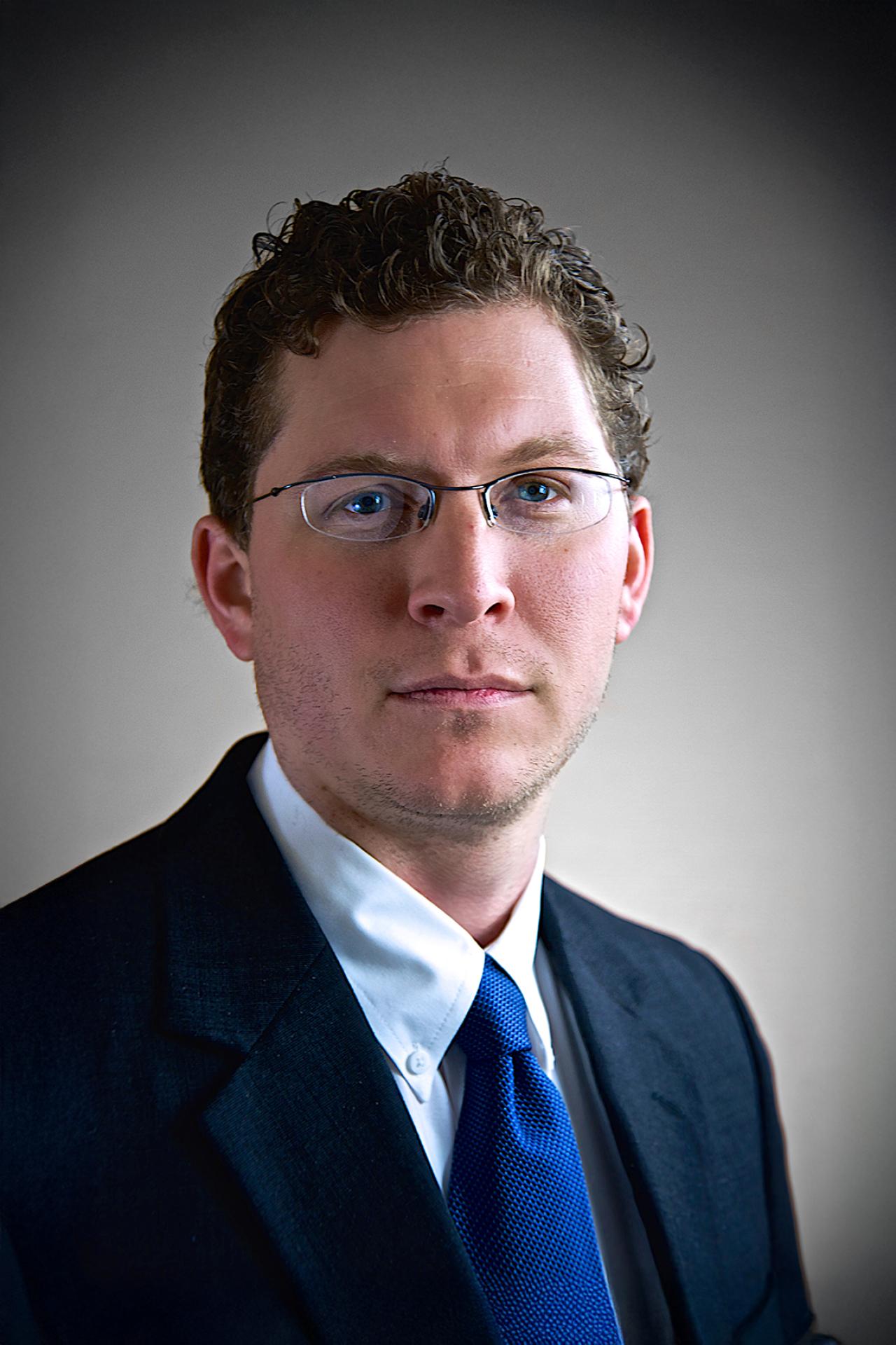 NYU SPS CE instructor Lucas Finco smiles for a photo wearing construction gear and a hardhat