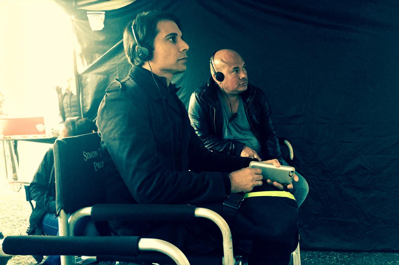 NYU SPS CE instructor Simon TaufiQue sits in a chair next to a colleague on a film set