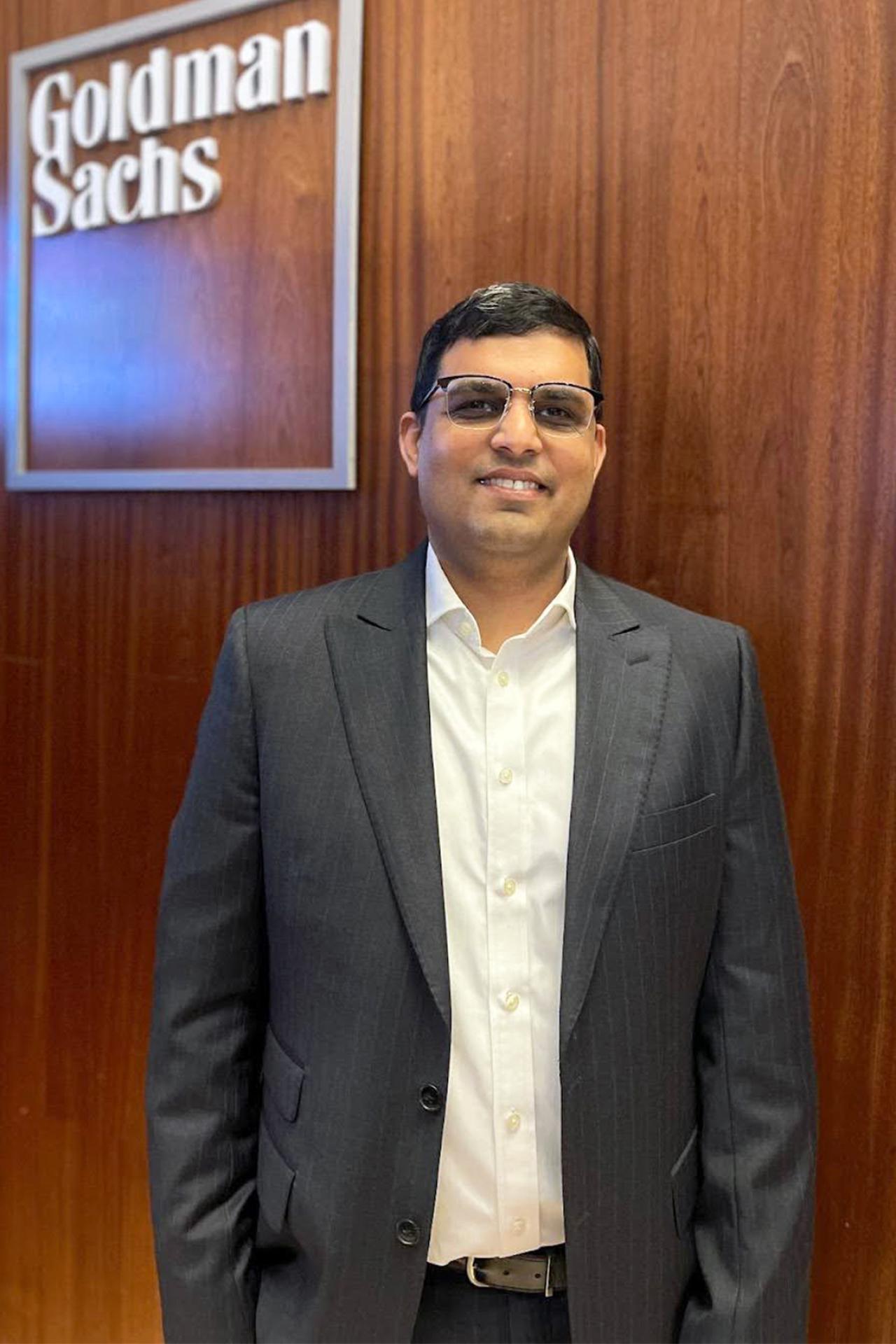 NYU SPS CE instructor Vinit Adya smiles for a photo in front of a Goldman Sachs sign