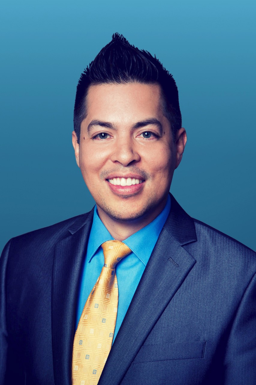Headshot of Raul Sanchez smiling wearing a suit and tie.