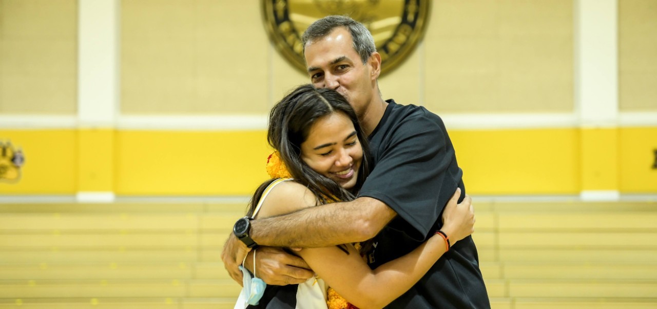 Alekhya Mangharam, student at the Preston Robert Tisch Institute for Global Sport at NYU SPS, embraces a loved one during a sporting event.