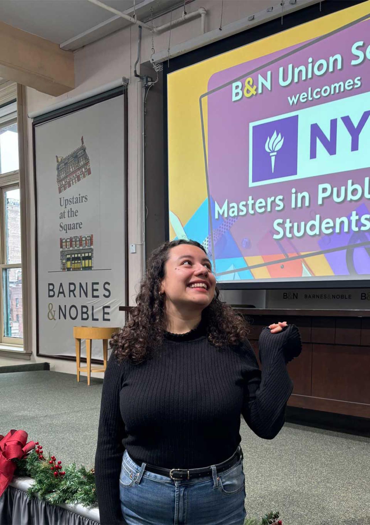 Luisa Castaneda posing in front of the Barnes & Noble and NYU Masters in Publishing event.