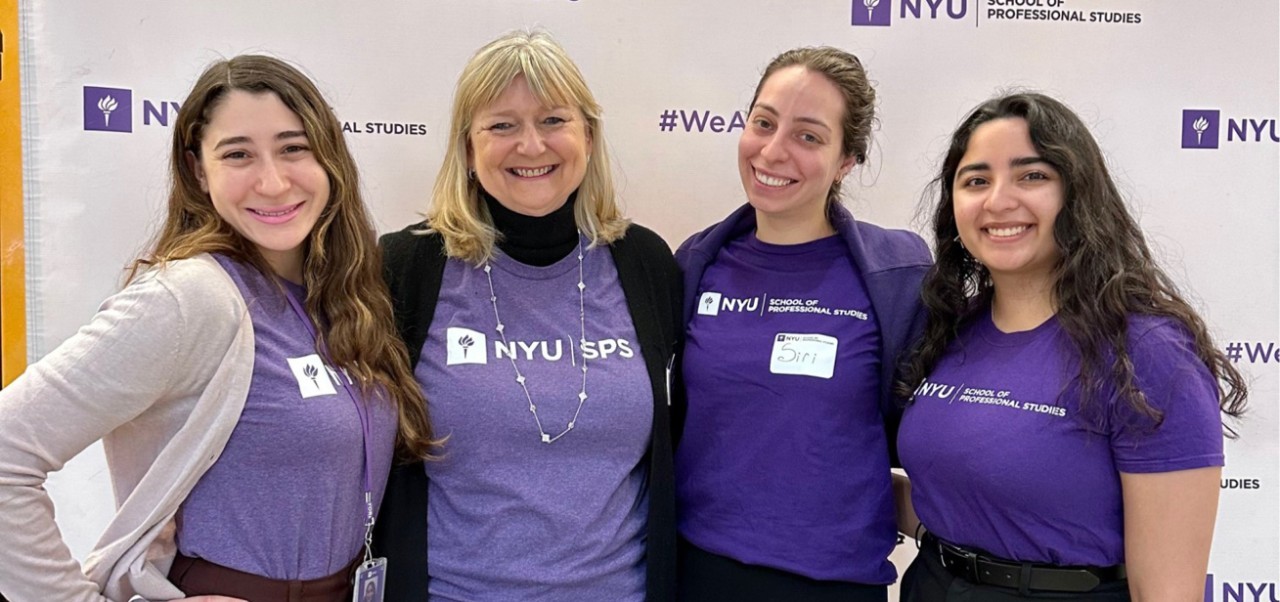 Siri Kostanyan, Division of Business Programs student at NYU SPS, poses for a photo with three other members of the NYU SPS community, all dressed in purple shirts.