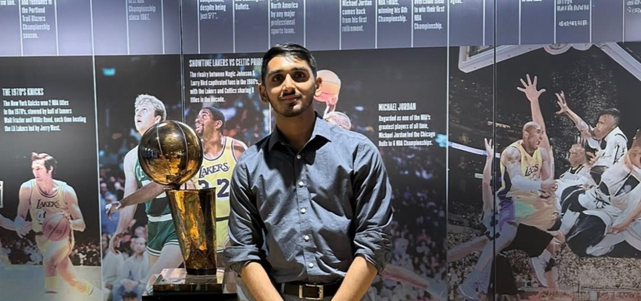 NYU SPS student Yash Gupta poses with NBA champion trophy