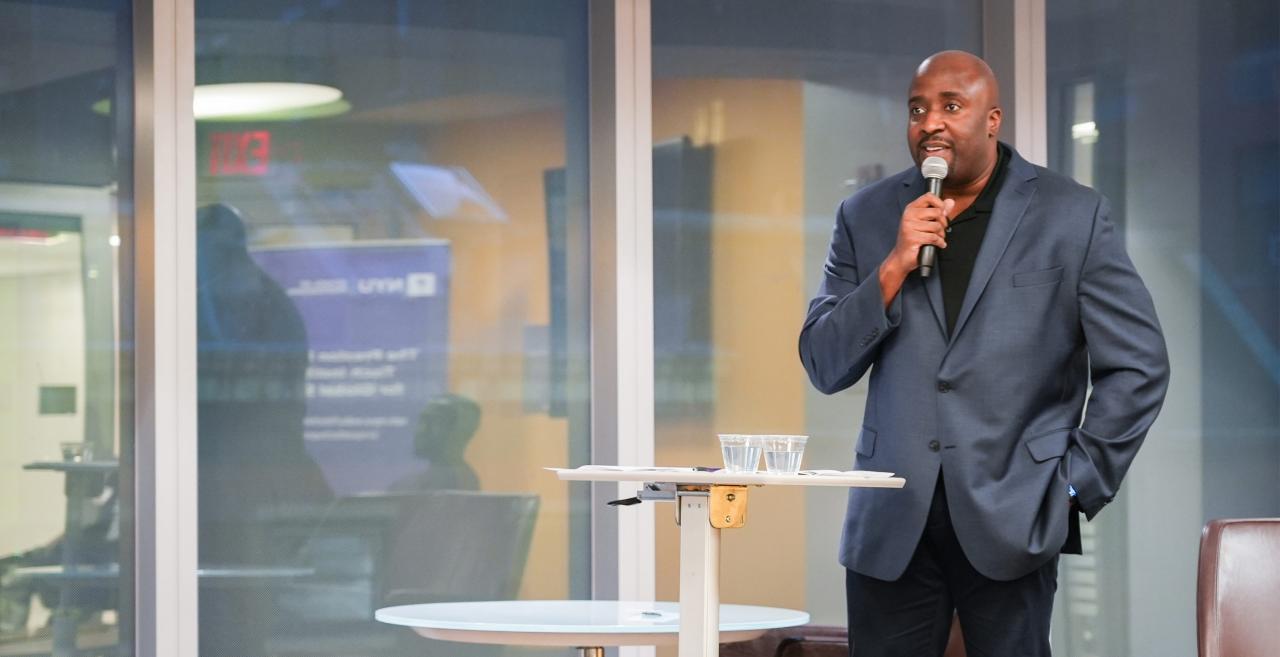 Tisch Institute Associate Dean Daniel G Kelly II speaks into a microphone.