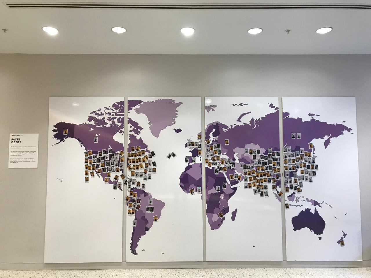 Map of world on wall with faces of each student where they are from