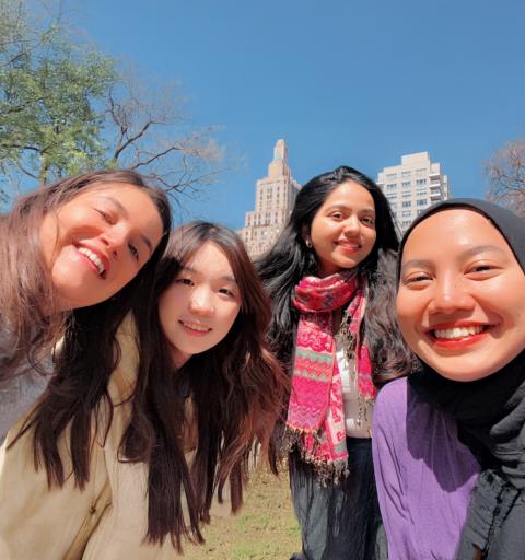 Four female NYU SPS scholarship students pose for a selfie in a park