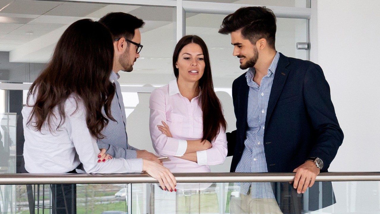 Students are having a meeting in front of a railing.