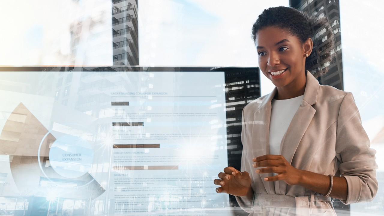 An IT professional stands in front of a digital display while giving a presentation.