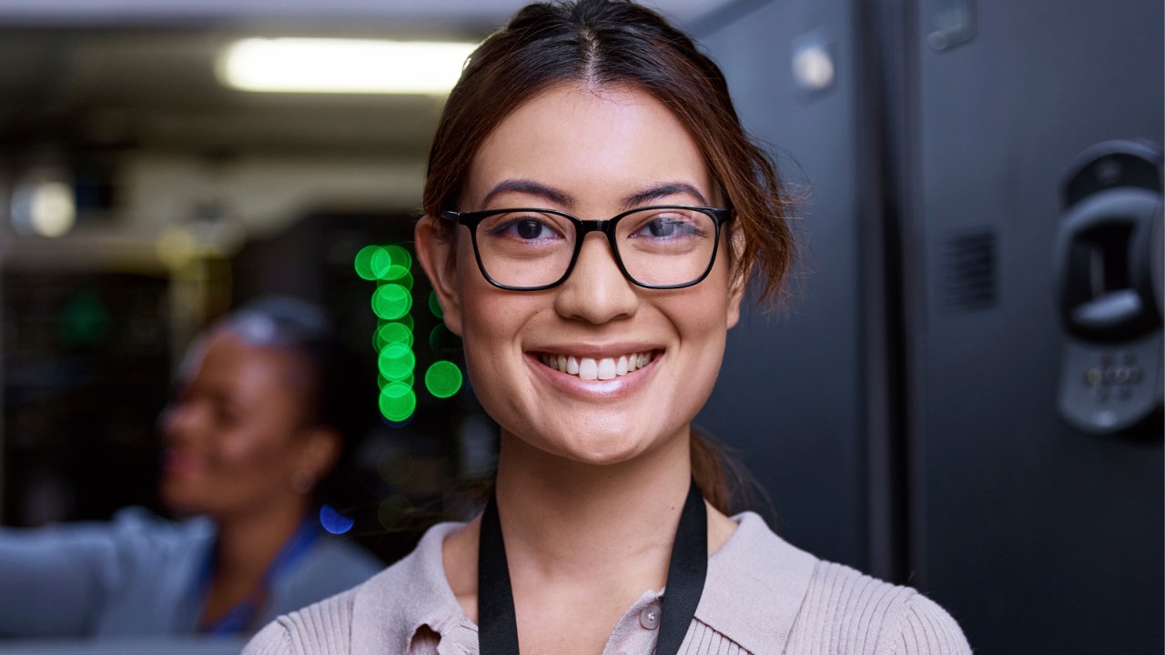 A woman online information systems degree student is in a computer information systems facility.